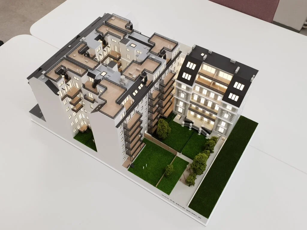 Architekturmodell Immobilien 1:100 – Wohnhaus mit geöffnetem Schnitt, sichtbaren Wohnungen und Innenhof.