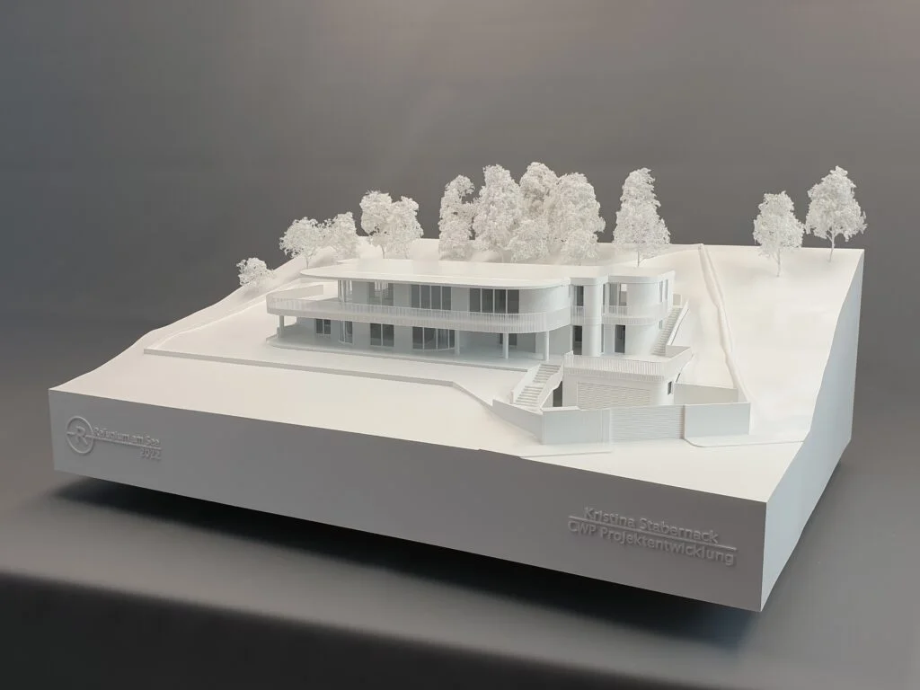 Architekturmodell Immobilien 1:100 – Einfamilienhaus mit Terrassen, Hanglage und detaillierter Umgebung.