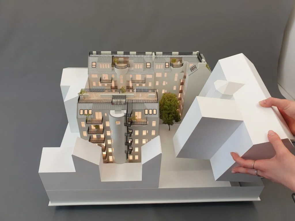 Architekturmodell Immobilien 1:100 – Wohnhaus mit geöffnetem Gebäudeschnitt, Innenhof und Beleuchtung.