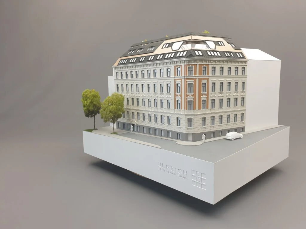 Architekturmodell Immobilien 1:100 – historisches Eckhaus mit Fassade, Dachausbau und Bäumen.