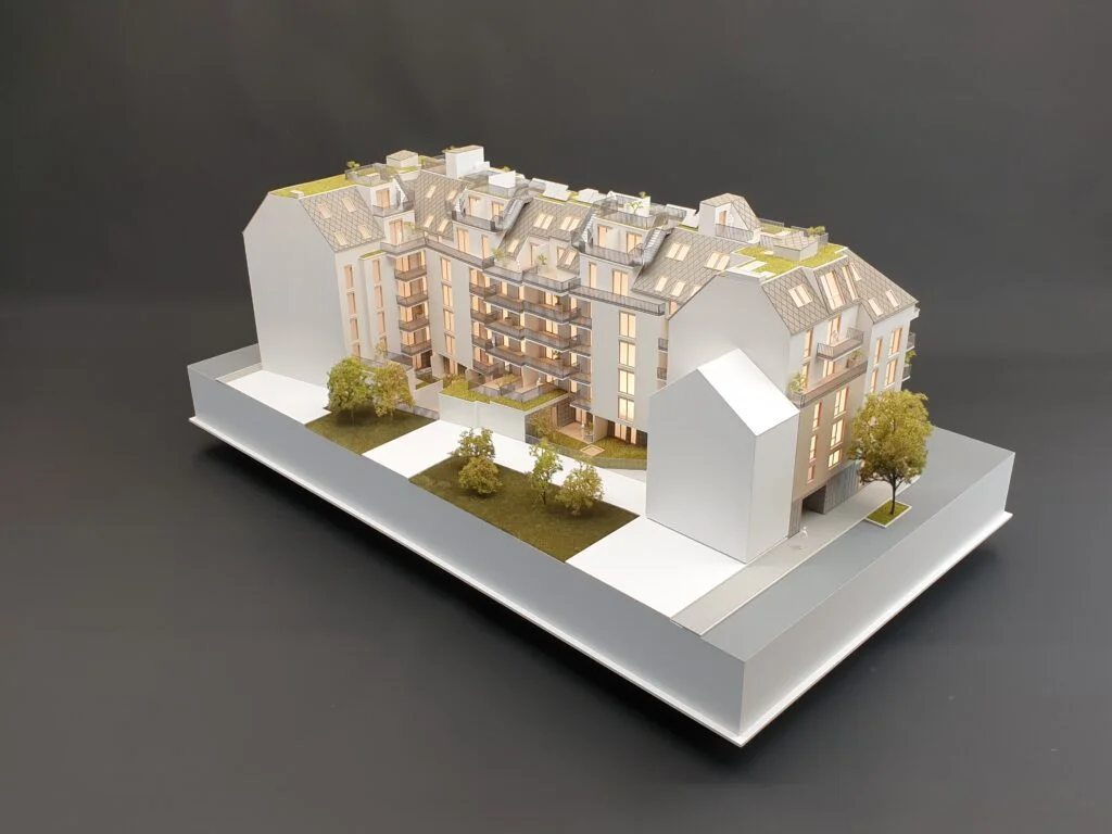 Architekturmodell Immobilien 1:100 – Wohnhausblock mit Dachbegrünung, begrüntem Innenhof und Fassadendetails.