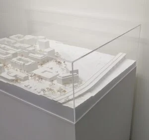 Umgebungsmodell – Stadtquartier mit weißen Baukörpern, Straßen, Bäumen und Acrylglasabdeckung für Wettbewerbspräsentation.