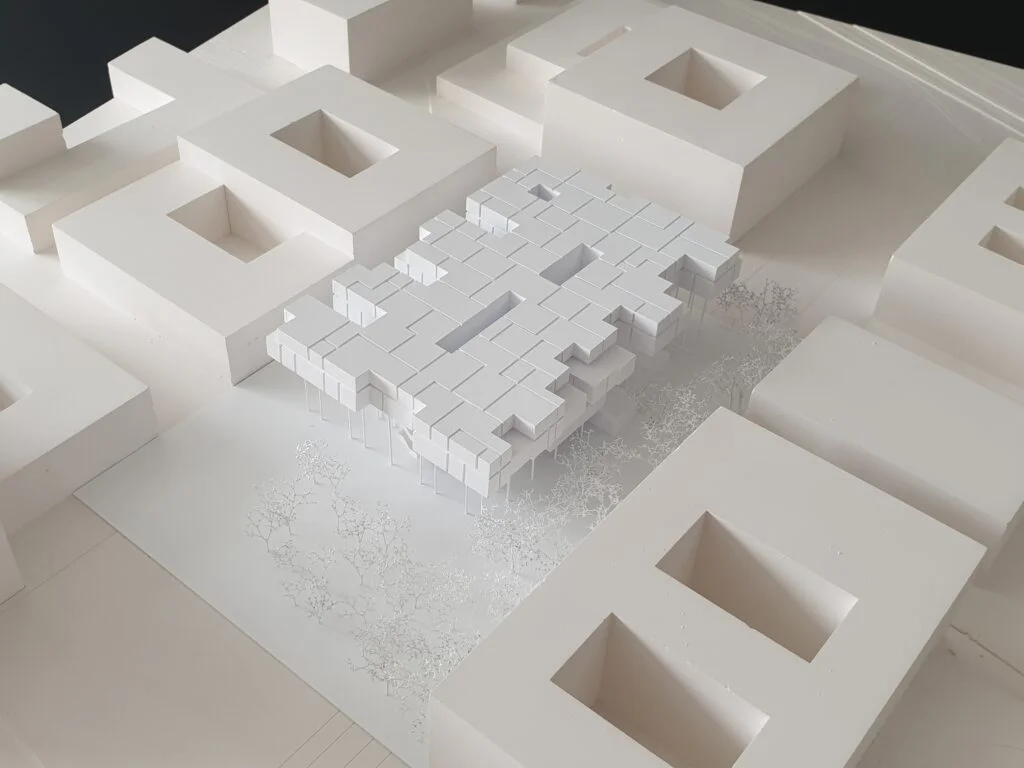 Architekturmodell Wettbewerb 1:500 – Stadtblock mit rechteckigen Baukörpern und neuem Gebäude im Innenhof.