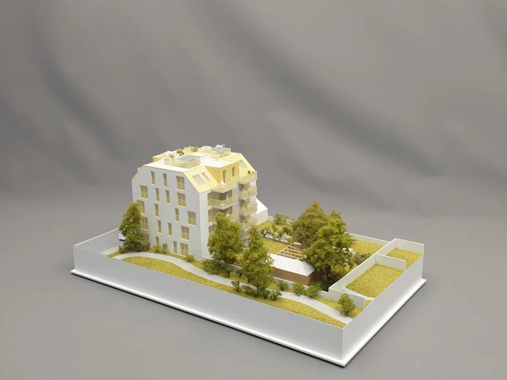 Architekturmodell Immobilien 1:100 – Wohnhaus mit Dachterrassen, Bäumen und Außenbegrünung.