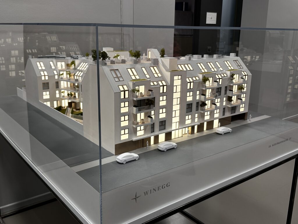 Architekturmodell Wohnblock mit LED-Beleuchtung, Balkonen und Dachbegrünung in Acrylglasvitrine.