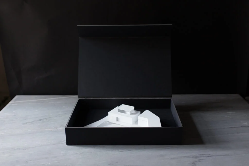 Architekturmodell in geöffneter schwarzer Box – elegante Verpackung für sicheren Transport und professionelle Übergabe.