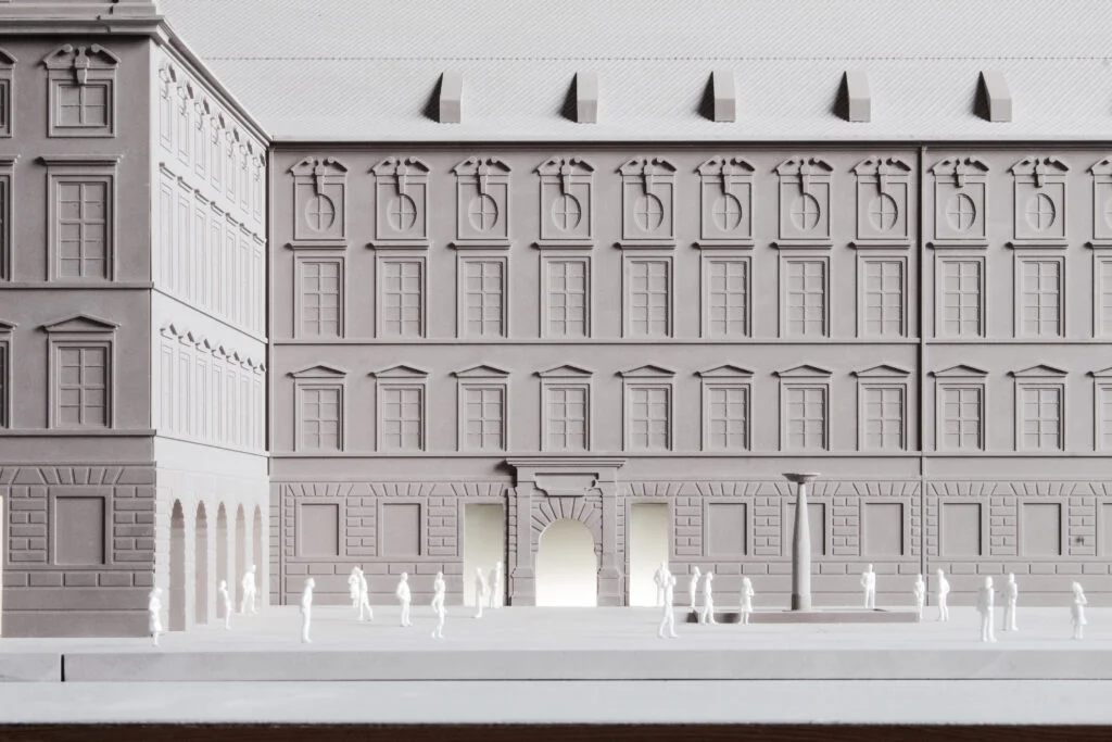 Architekturmodell 1:100 – detailgetreue Darstellung einer historischen Gebäudefassade mit Figuren und Platzgestaltung.