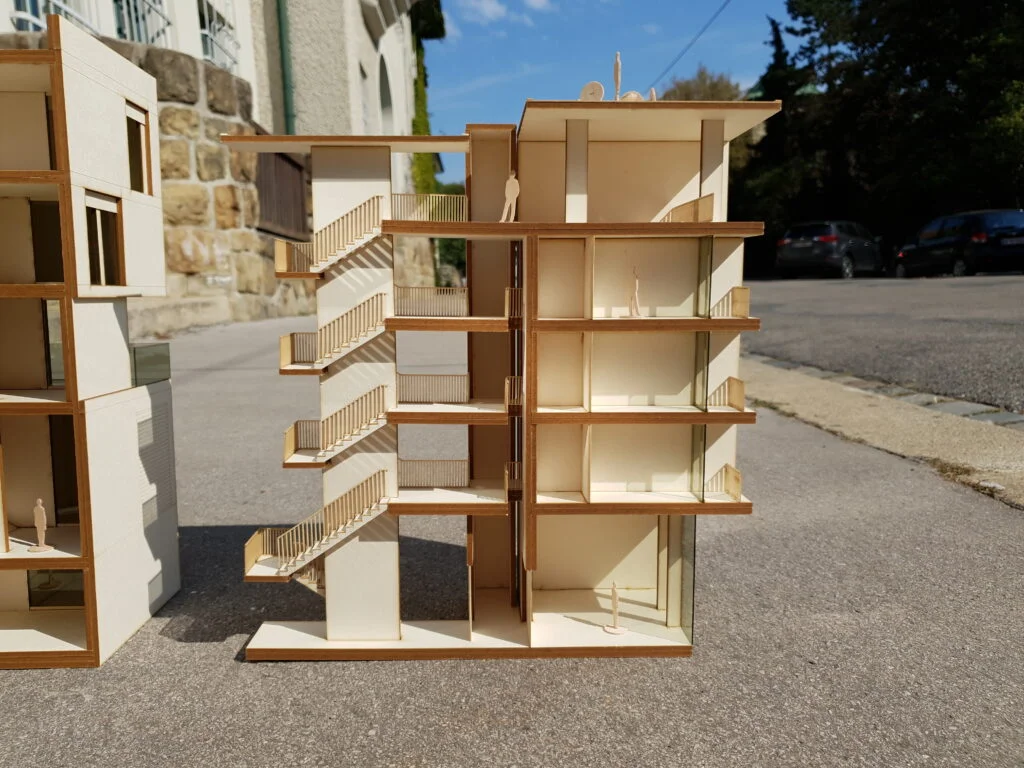 Funktionsmodell Wohnhaus im Schnitt mit Treppenhaus, offenen Etagen und abstrahierten Figuren für Planung und Präsentation.