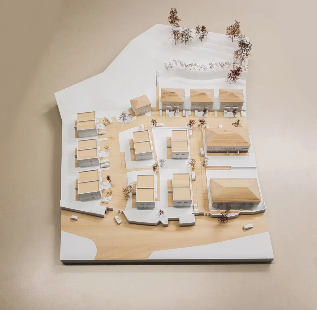 Architekturmodell aus Holz – Wohnsiedlung mit Einfamilienhäusern, Zufahrten und Bepflanzung.