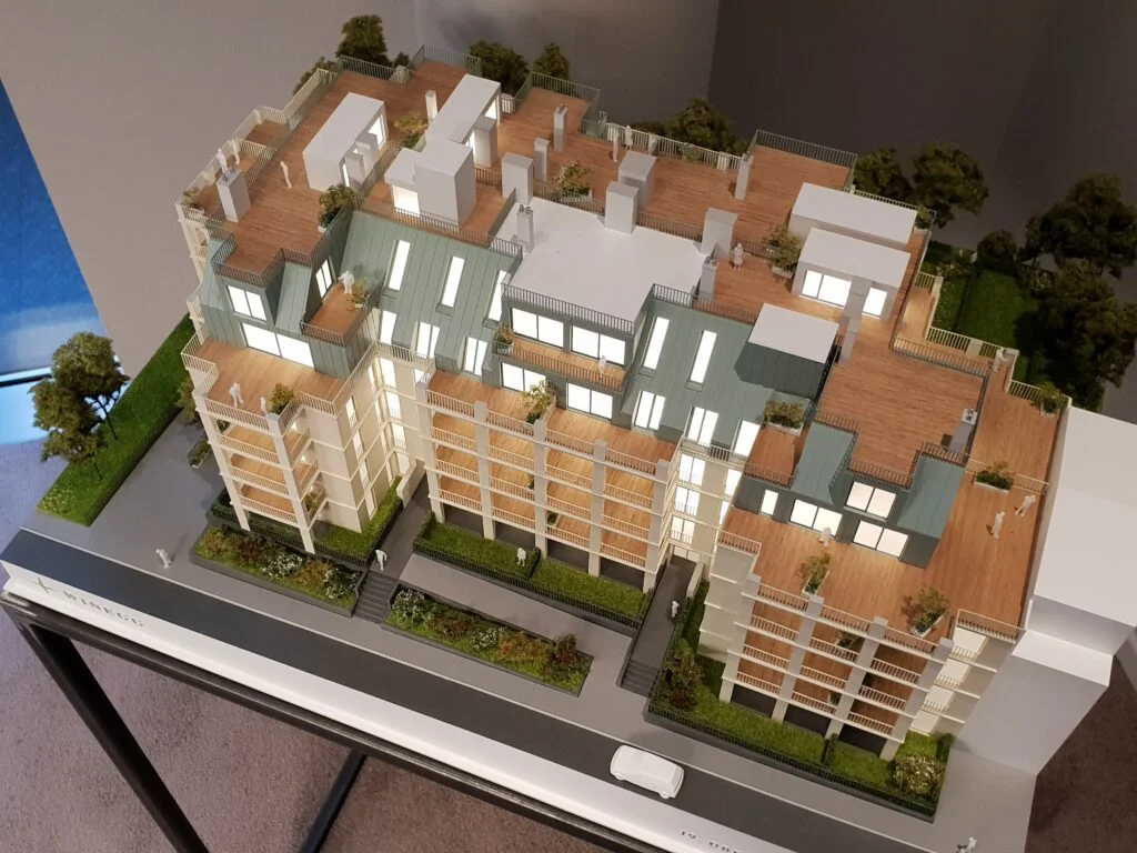 Vollfarbiges Architekturmodell 1:100 – Wohnhaus mit Dachterrassen, Begrünung und Beleuchtung.