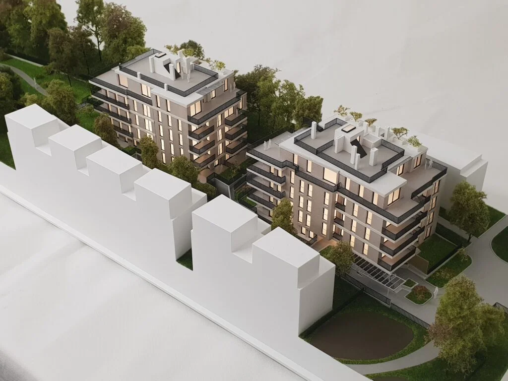 Architekturmodell Wien – Immobilienmodell mit zwei Wohngebäuden, Balkonen, Grünflächen und stimmungsvoller Beleuchtung.
