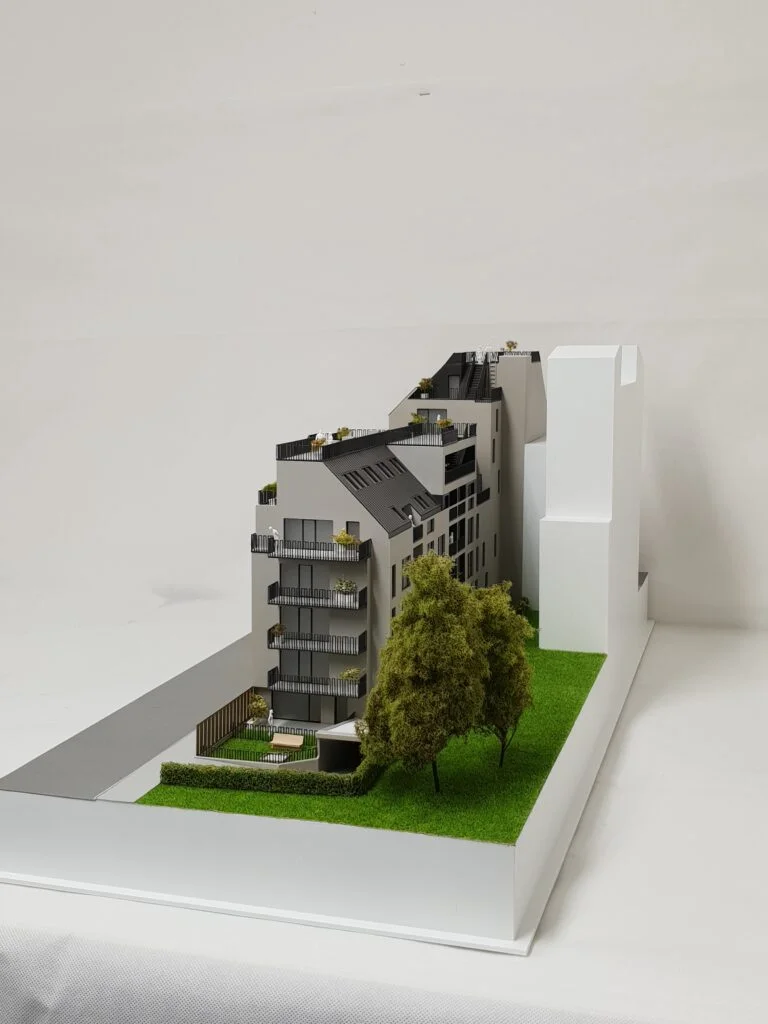 Vollfarbiges Architekturmodell 1:100 – Wohnhaus mit Terrassen, Balkonen und Grünflächen.