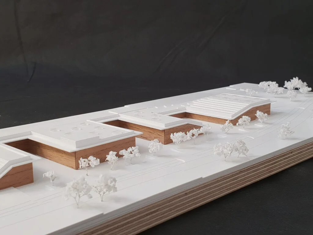 Architekturmodell Schule – Kombination aus Holz- und Weißbau mit detaillierter Umgebung und Bäumen.