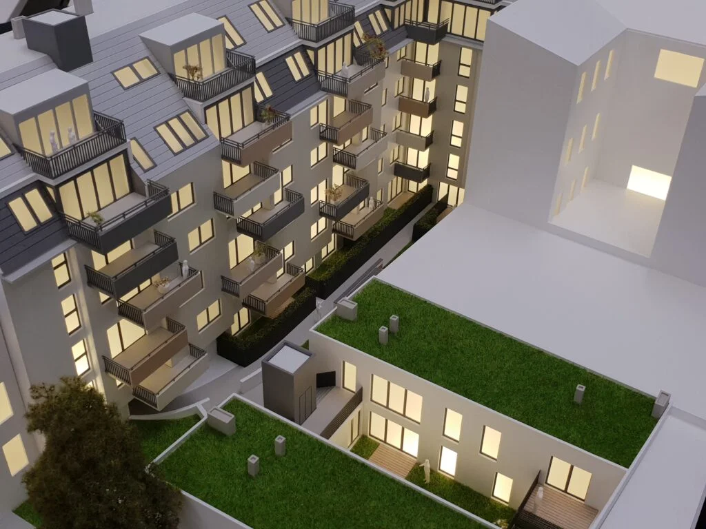 Vollfarbiges Architekturmodell 1:100 – Wohnhaus mit Balkonen, Beleuchtung und grünen Dachflächen.