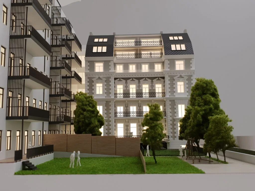 Architekturmodell Altbau – detailreiches Immobilienmodell mit sanierter Fassade, Balkonen, Grünflächen und Beleuchtung.