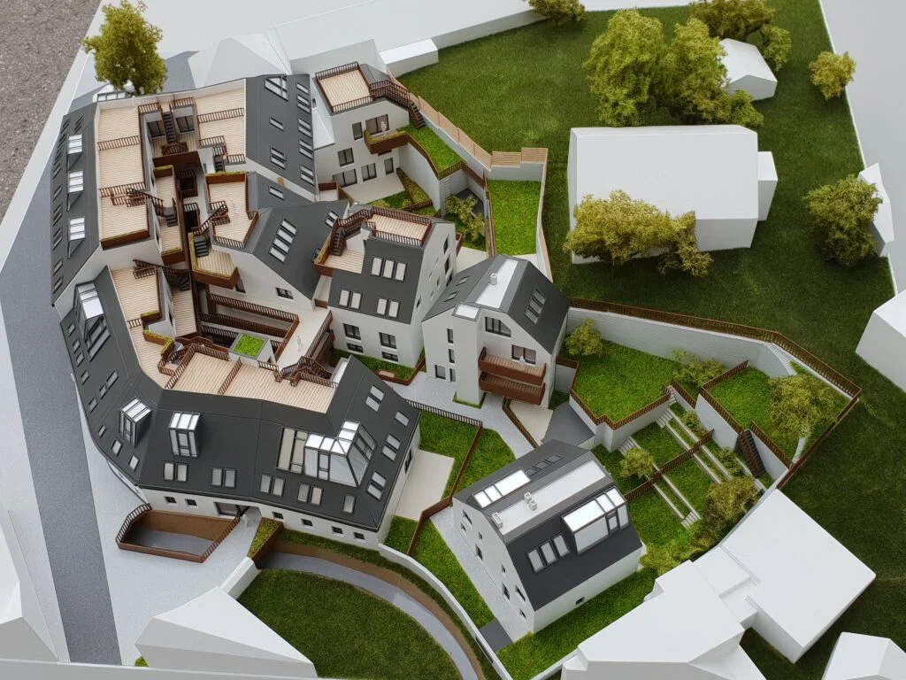 Vollfarbiges Architekturmodell – Wohnanlage mit Terrassen, Innenhöfen und Grünflächen.