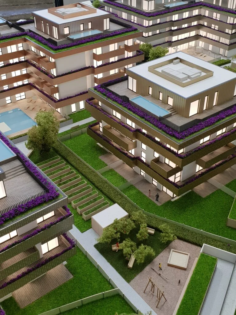 : Vollfarbiges Architekturmodell – Wohnanlage mit Balkonen, Grünflächen und Spielplatz.