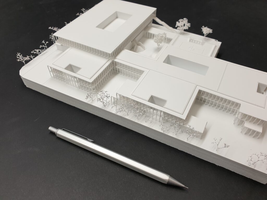 3D-Druck Wettbewerbsmodell 1:500 – Architekturmodell eines Campusprojekts mit klaren Fassaden, Innenhöfen und filigranen Bäumen.