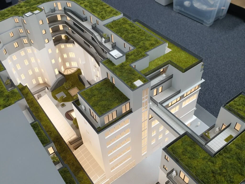 Verkaufsmodell Wohngebäude mit Innenhof, begrünten Dächern und Stegen – detailreiches Immobilienmodell für Präsentationen.