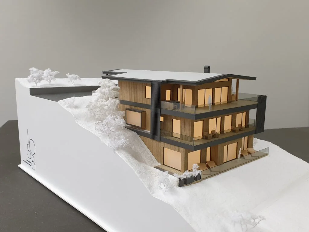 Architekturmodell 1:50/1:75 – dreigeschossiges Berghaus mit Holzfassade, Glasfronten, Balkonen und Hanglage.