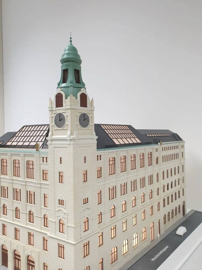 Architekturmodell 1:100 – historisches Gebäude mit Uhrturm, Fassadendetails und beleuchteten Innenräumen.