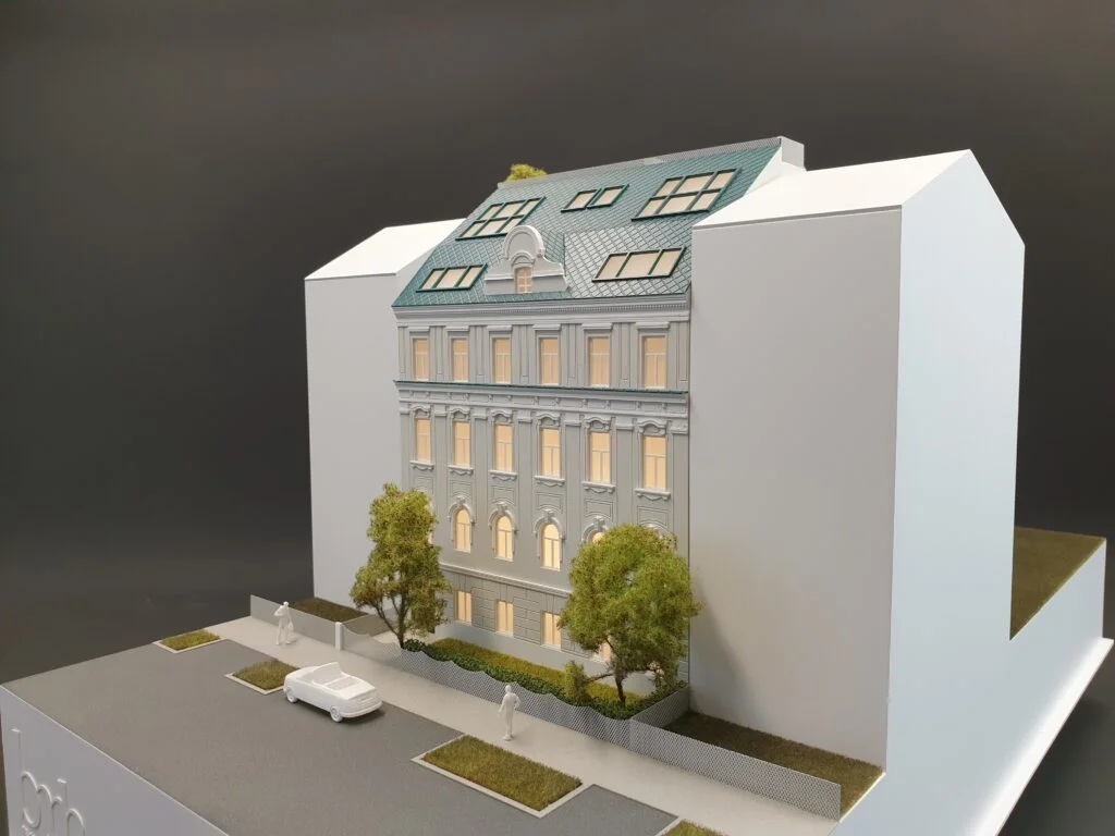 Architekturmodell Altbau Wien – Immobilienmodell mit Beleuchtung, sanierter Fassade, Dachgeschossausbau und Grünflächen.