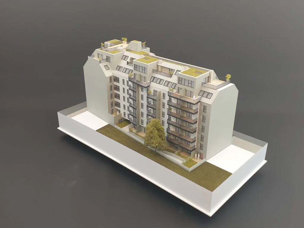 Architekturmodell eines Wohngebäudes – detailreiches Immobilienmodell mit Balkonen, Dachterrassen und Grünflächen für Präsentation und Verkauf.