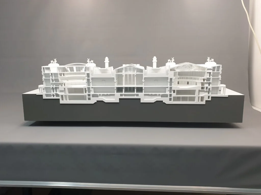 Architektur-Schnittmodell eines historischen Gebäudekomplexes mit Innenräumen, Dachstruktur und Fassade.