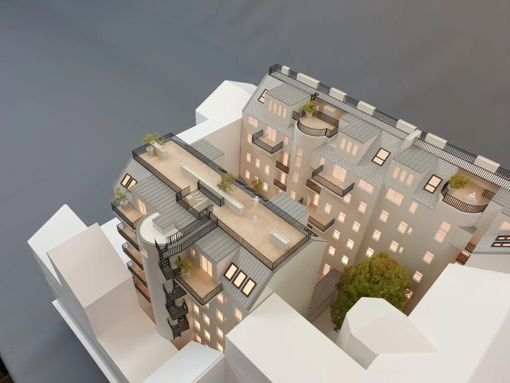 Architekturmodell Wohnhaus Wien – detailreiches Immobilienmodell mit beleuchtetem Innenhof, Dachterrassen und Balkonen.