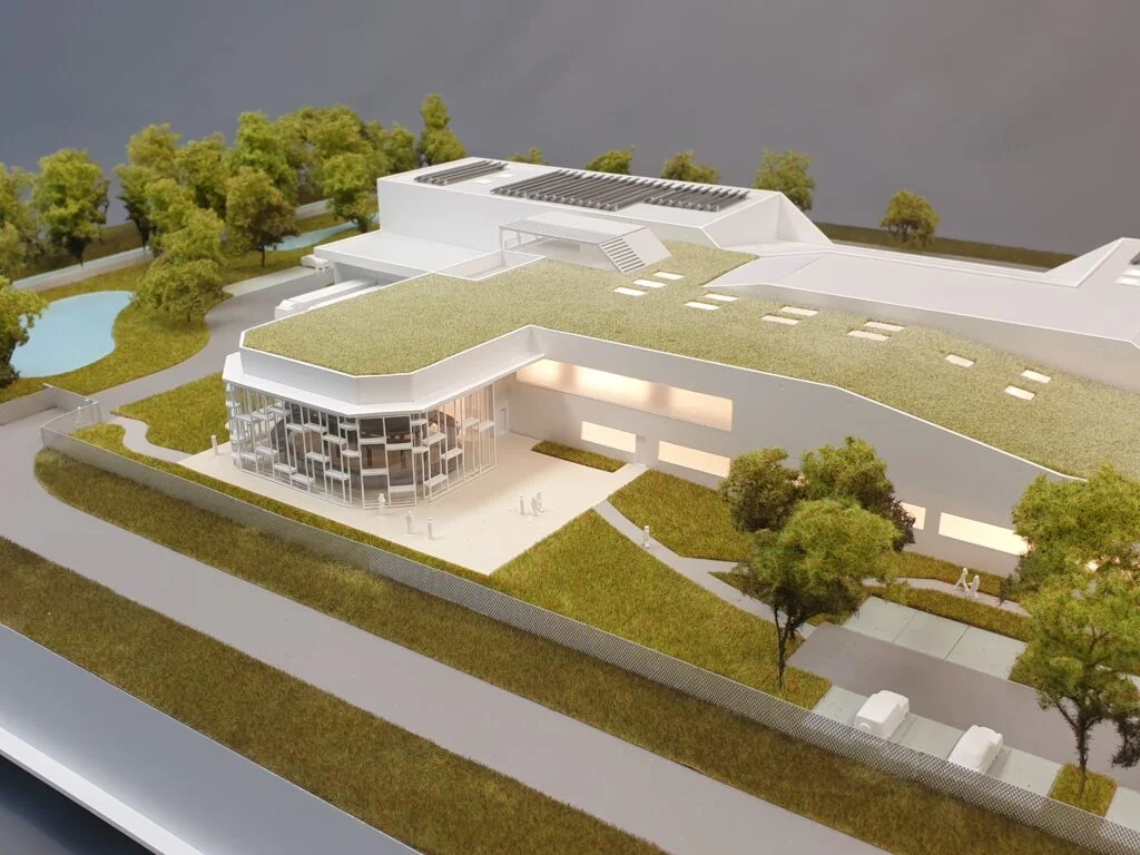 Architekturmodell Forschungszentrum 1:200 – moderne Anlage mit begrüntem Dach, Glasfassade, Landschaft und integrierter Beleuchtung.