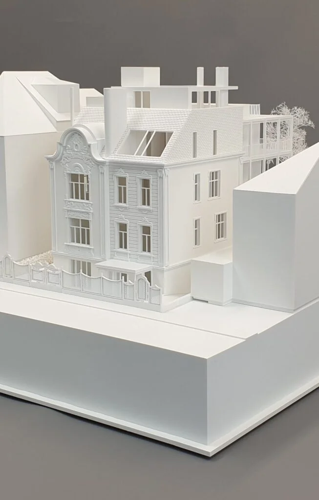 Architekturmodell – Wohnhaus mit historischer Fassade, Dachaufstockung und homogener Darstellung mit stilisierten Bäumen.