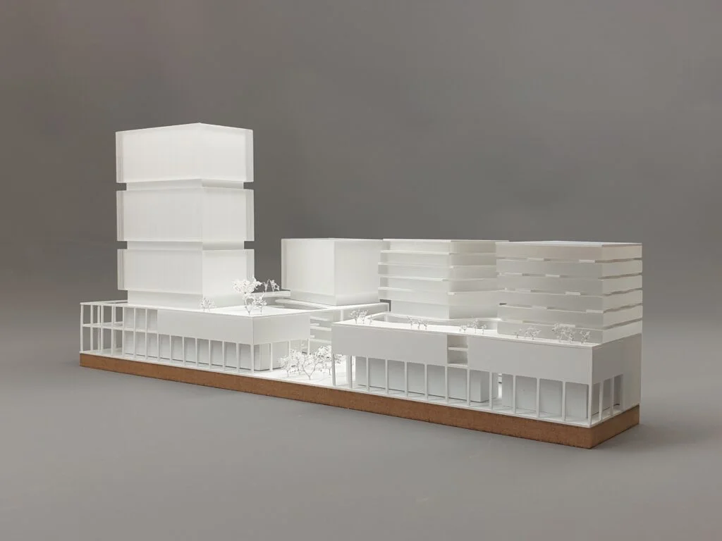 Wettbewerbsmodell 1:500 – Hochhaus mit gestapelten Volumen und Blockbebauung, klare Struktur, urbane Dichte.