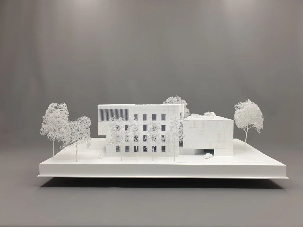 Architekturmodell – modernes Gebäude mit homogener Darstellung, klarer Fassadengliederung und stilisierten Bäumen.