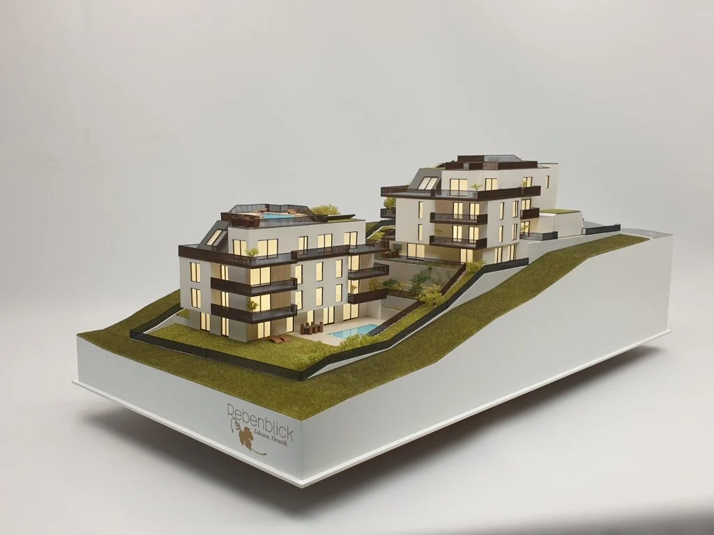 Verkaufsmodell „Rebenblick“ – Architekturmodell mit Holzdetails, Terrassen, Pools und Beleuchtung in Hanglage.