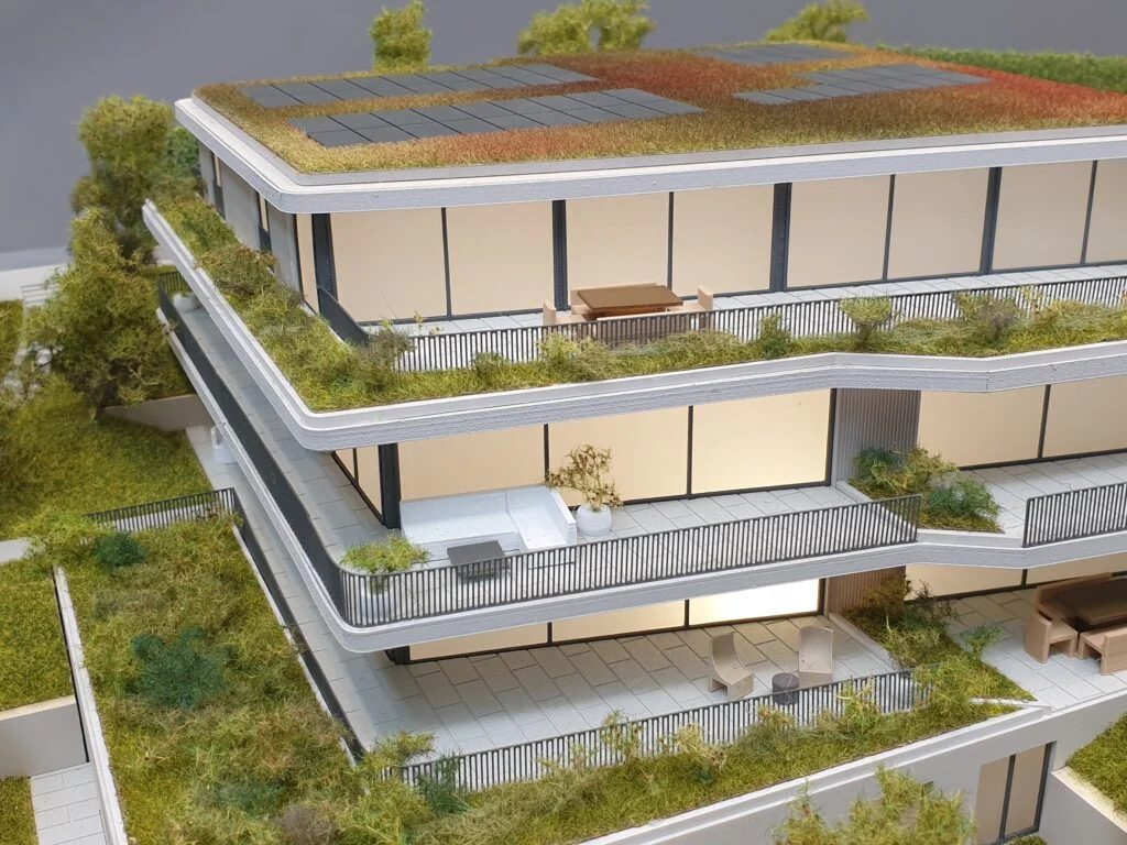 Detailliertes Architekturmodell – Verkaufsmodell eines Wohnhauses mit modernen Balkonen, großen Fensterflächen und Gründach.
