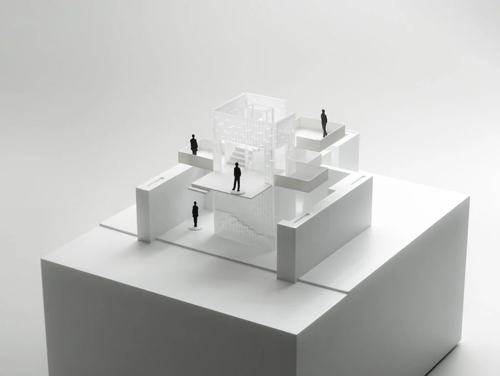 Geschenkidee Architekturmodell – modernes, weißes Modell mit Acrylglas und schwarzen Figuren, minimalistisch gestaltet.