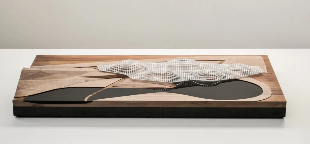 Kunstmodell – Architekturmodell aus Holz mit Acrylraster, topografischer Gestaltung, Wasserflächen und künstlerischer Ästhetik.