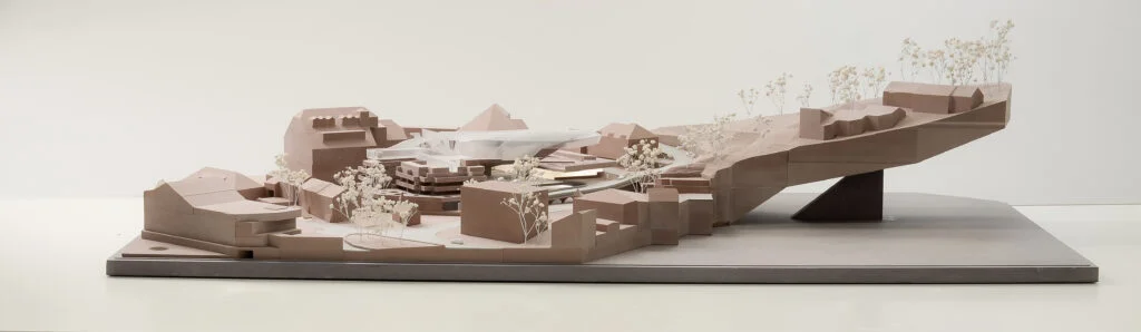 Homogenes Architekturmodell – topografisches Gelände mit Bauvolumen, abstrahierten Gebäuden und Vegetation im Wettbewerbsmaßstab.