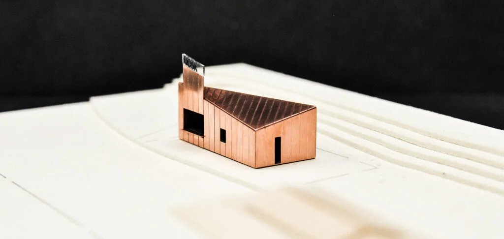 Kupfermodell – architektonisches Hausmodell mit Schornstein auf weißem Geländesockel.