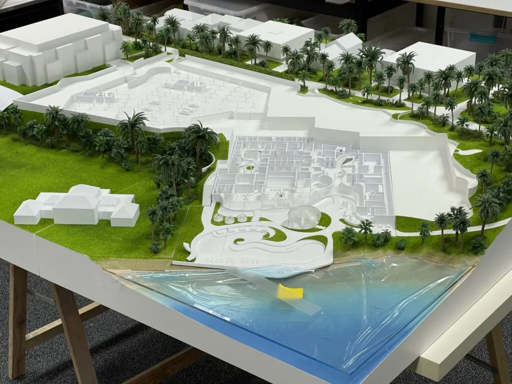 Architekturmodell mit offenen Elementen – Resort mit sichtbaren Innenräumen, Palmen, Grünflächen und Meereszugang.
