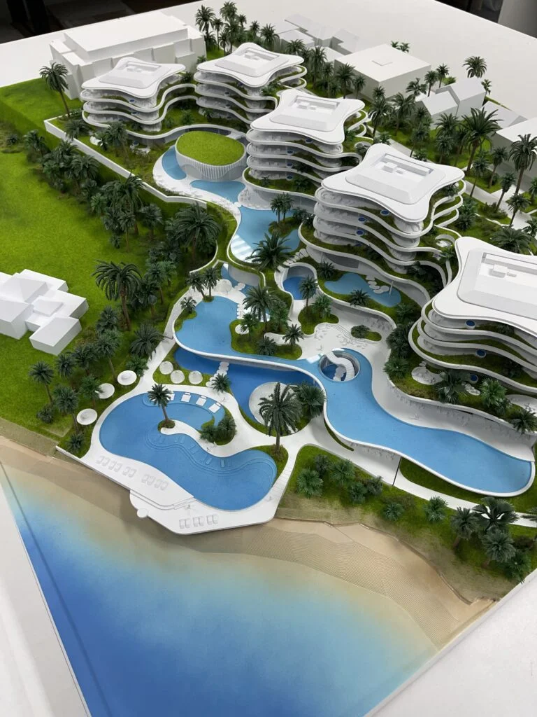 Architekturmodell Resort am Meer – Hotelanlage mit Pools, Palmen, Strandzugang und geschwungenen Baukörpern in futuristischem Design.