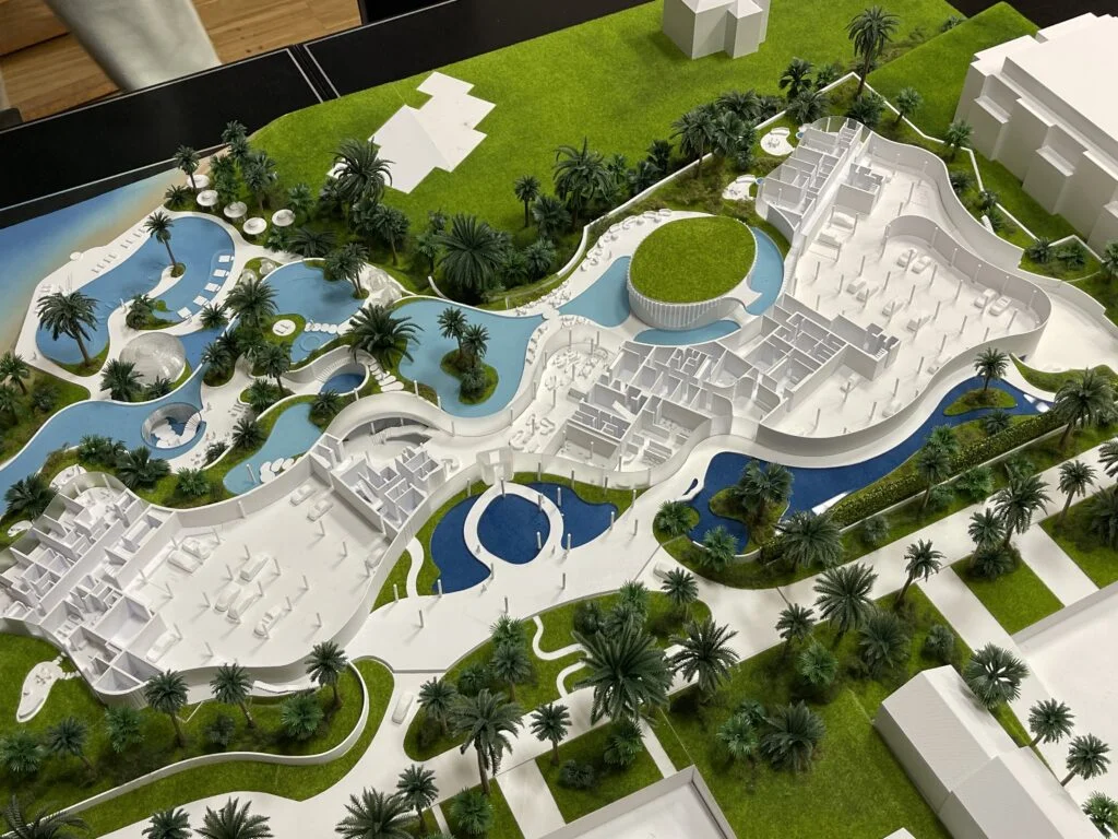 Architekturmodell mit offenen Elementen – Resort mit sichtbaren Innenräumen, Pools, Palmen und Grünflächen.