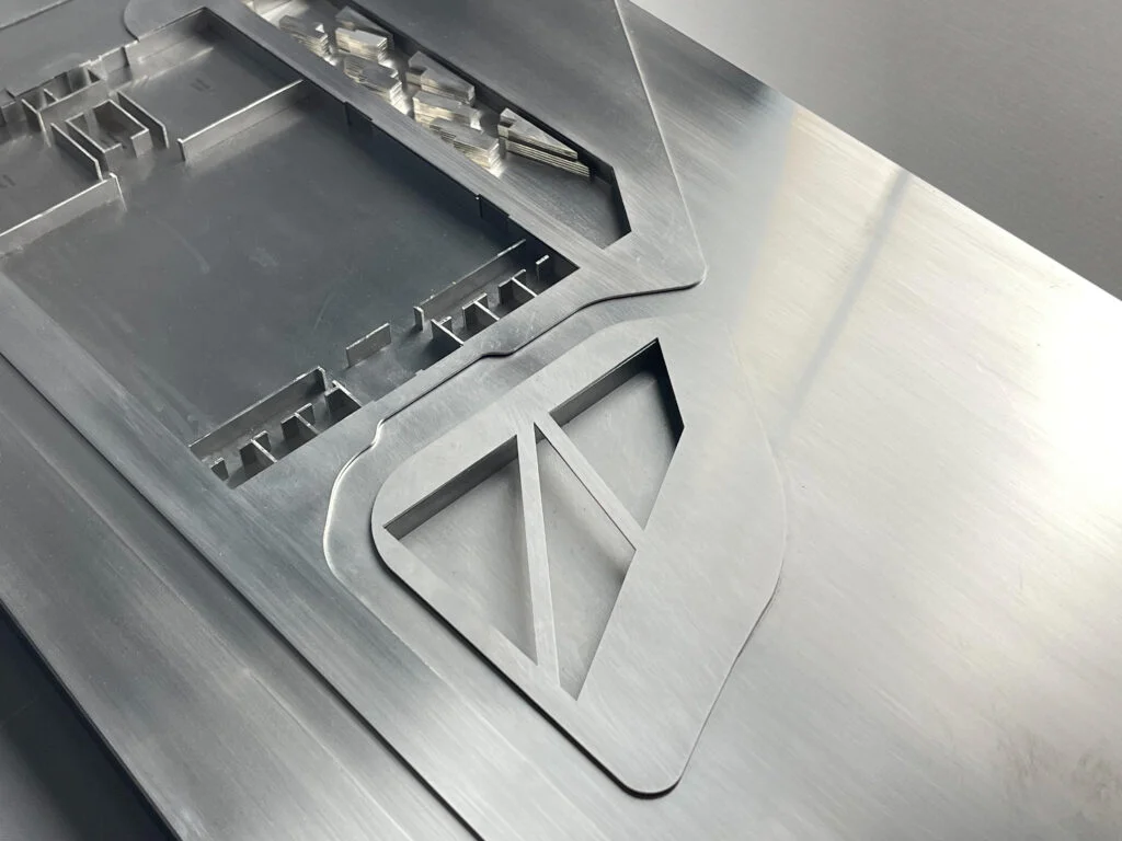 Metallmodell – abstrahiertes Architekturmodell mit gravierten Flächen und geometrischen Reliefstrukturen.