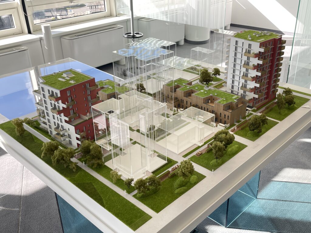 Vollfarbiges Architekturmodell 1:100 – Wohnquartier mit mehreren Gebäuden, Grünflächen und begrünten Dächern.