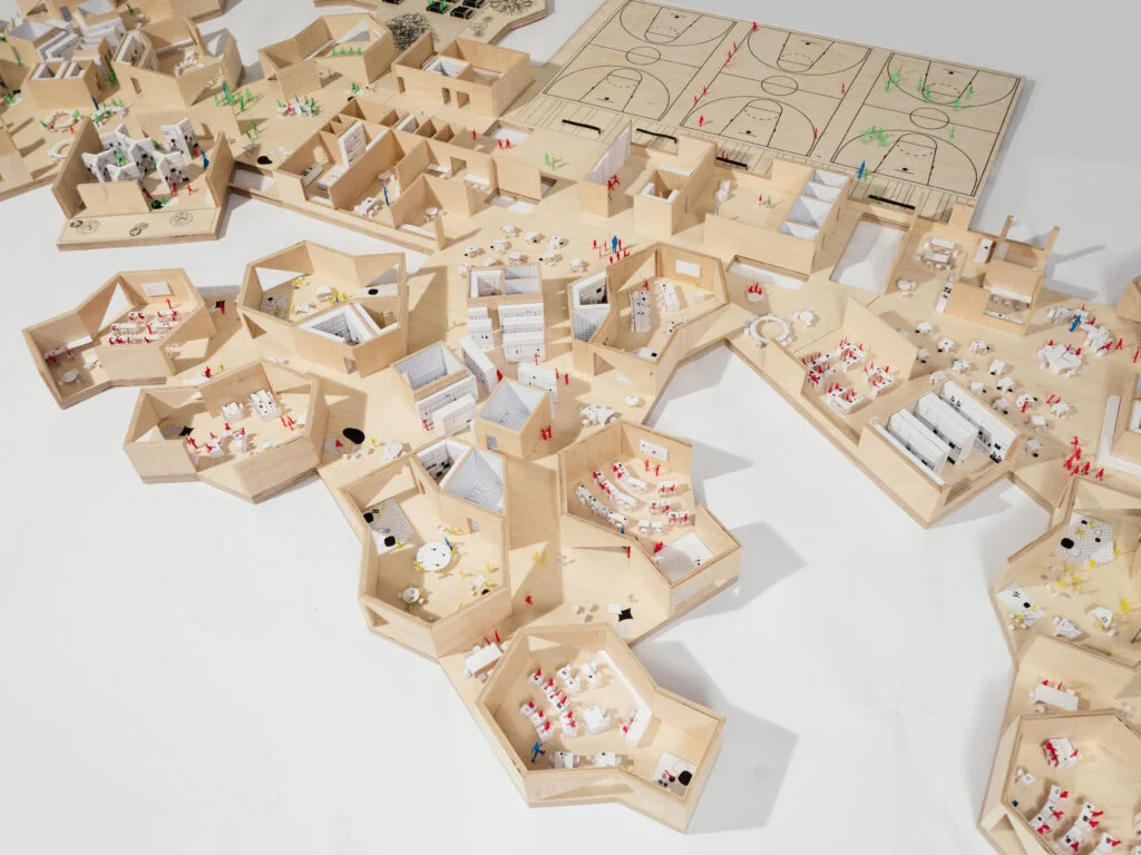 Architekturmodell Campus – Holzmodell mit hexagonalen Modulen, offenen Innenräumen und Sportplätzen.