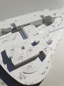 Weißes 3D-Druck Modell für Stadtplanung mit aufgedruckten Bäumen und Wegen, zeigt Gebäudevolumen und Freiraumgestaltung.