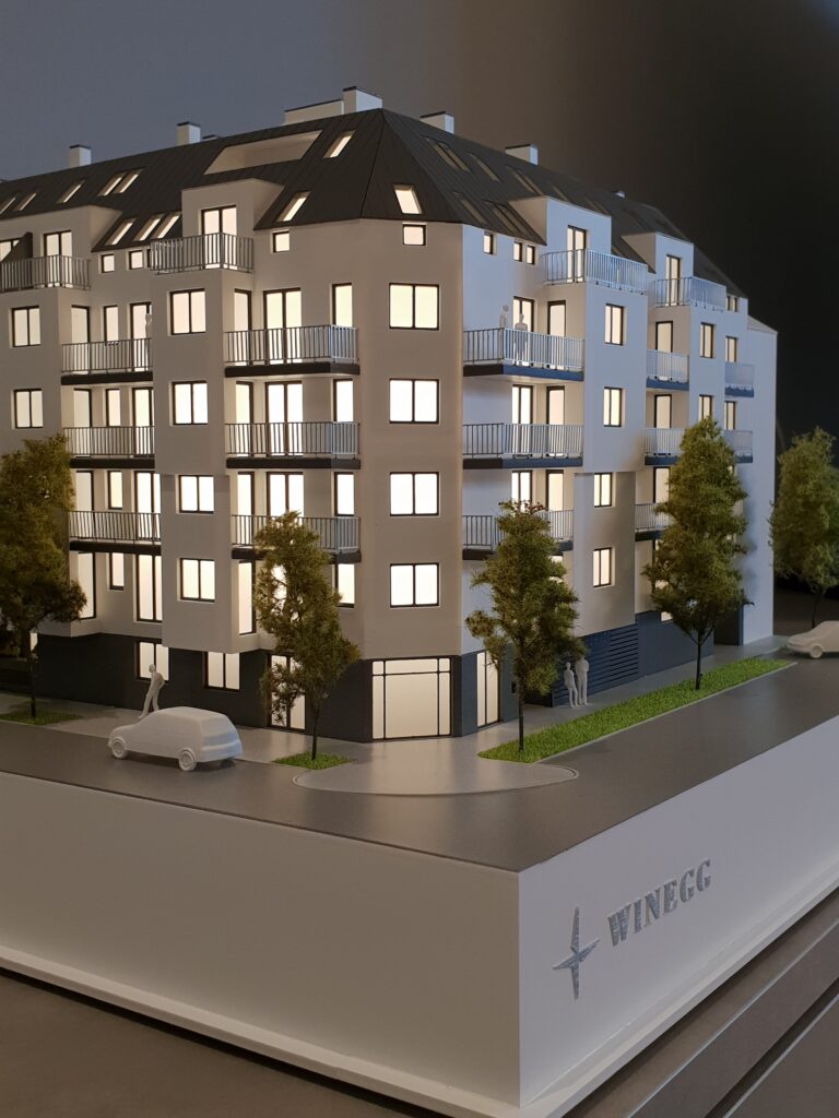 Verkaufsmodell Mehrfamilienhaus mit Beleuchtung, Fassadendetails und Begrünung, Architekturmodell für Immobilienpräsentationen.