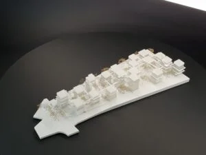 Weißes 3D-Druck Modell mit vielen Baukörpern und Bäumen, städtebauliches Konzept auf länglicher Grundplatte, präsentiert auf dunklem Hintergrund.