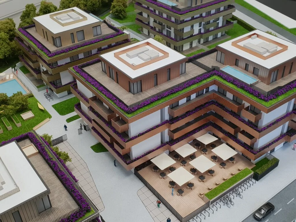 Architekturmodell Wohnanlage – moderne Gebäude mit Dachterrassen, Garten, Pool und Sitzbereichen für Präsentationen.