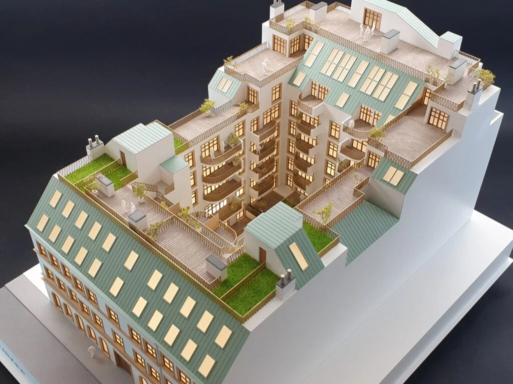 Architekturmodell – Dachausbau eines Wohnhauses mit begrünten Terrassen, Balkonen und Lichtinstallation.